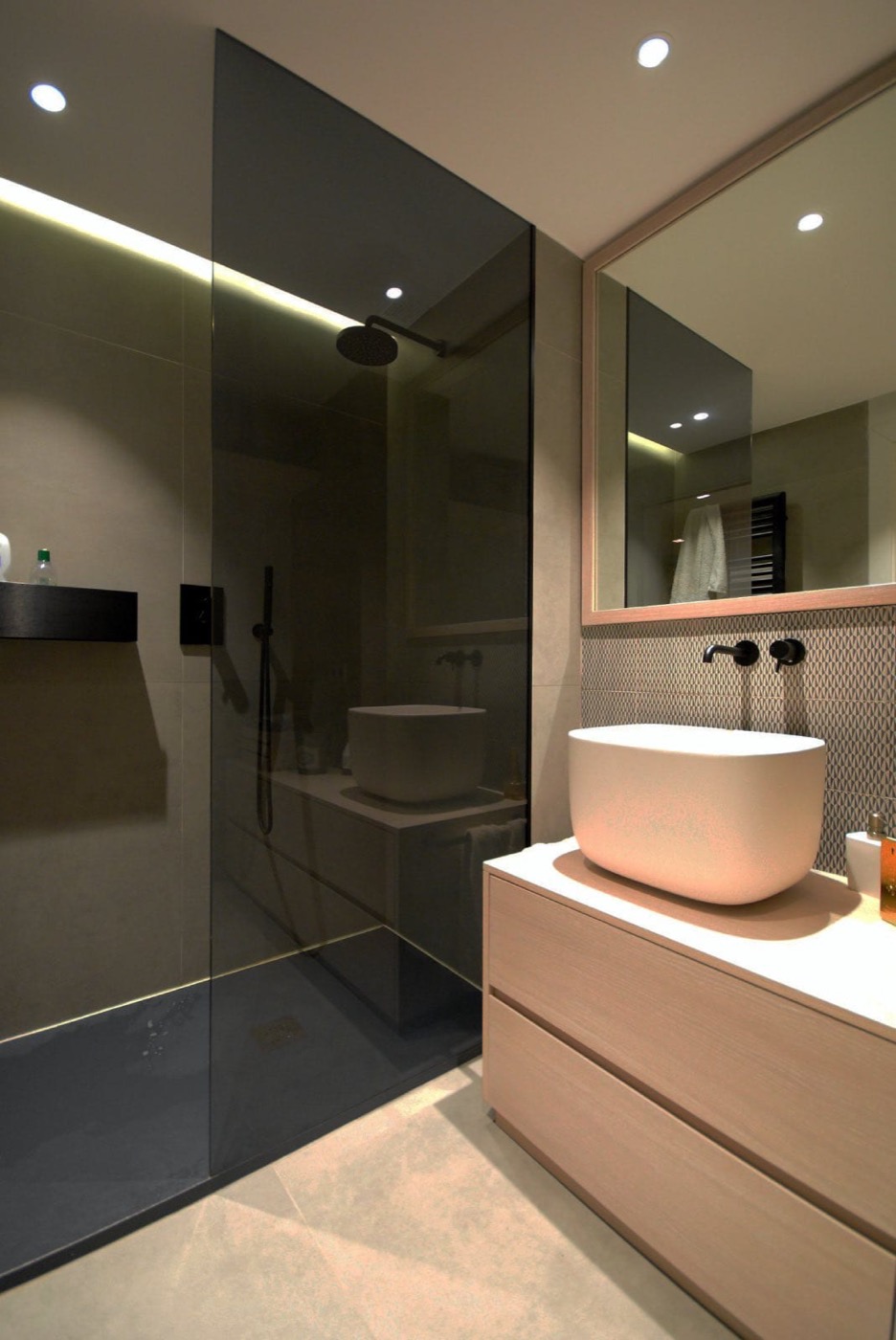 Baño moderno terminado con mampara negra y mueble de madera